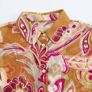 Close-up of golden paisley chiffon shirt collar with high-quality printing and white buttons