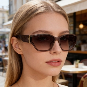 Detail of square oversized sunglasses featuring gradient lenses and gold hinge accents