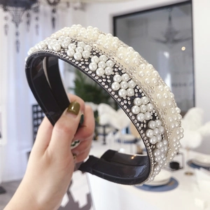 Luxurious wide headband with white faux pearls and rhinestones on a black base