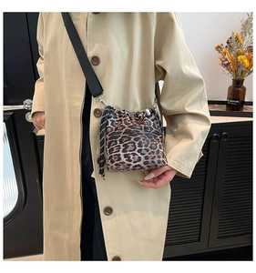 Dettaglio della borsa a secchiello leopardata con coulisse e ampia tracolla in nylon nero