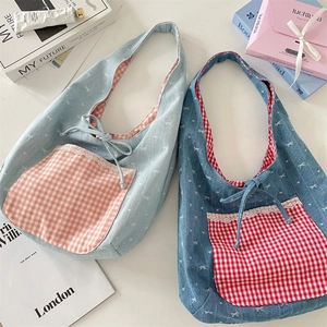 Detailed macro of denim hobo bags with white lace trim and contrast plaid pockets