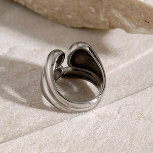 Macro detail of minimalist double-layered polished stainless steel ring on stone