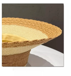 Close-up of the woven straw texture and wavy brim detail on this beige sun hat