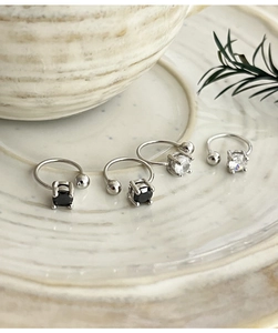 Detail of 925 sterling silver ear cuffs with black and white zircon stones on ceramic