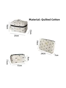 Three-piece quilted cotton makeup bag set with black bow embroidery details in ivory white