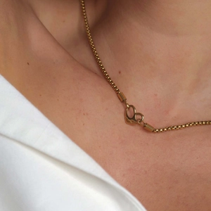Gold stainless steel double heart necklace with I am worthy engraving worn by a model