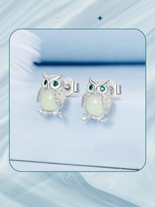 Detailed view of S925 silver owl earrings with luminous pearls and green gemstones