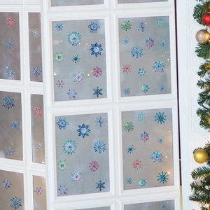 Close-up of colorful snowflake window stickers applied on white glass panes for Christmas