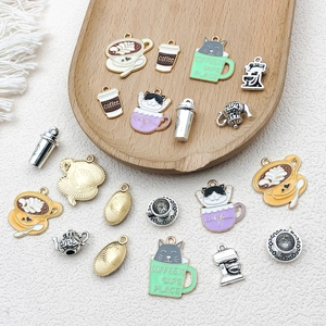 Detail of assorted vintage enamel coffee cups, kettles, and cat charms on a wooden tray
