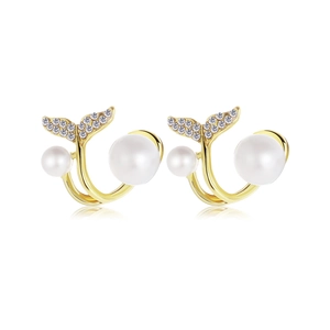 Macro detail of gold whale tail earrings with white pearls and sparkling pavé crystals