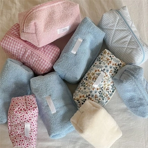 Close-up of quilted cotton and terry cloth makeup bags in various patterns and colors