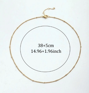 Detail view of gold bead chain necklace with adjustable lobster clasp and 38+5cm size label