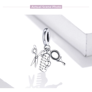 Macro detail of 925 silver salon charms with tiny scissors, comb, and hand mirror