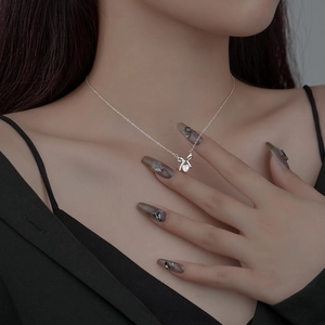 Elegant S925 sterling silver bow and heart necklace with shiny crystals on model neck