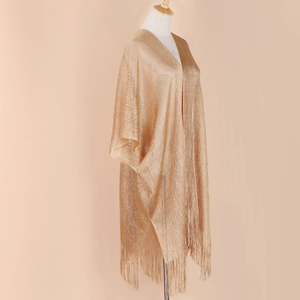 Detail of champagne gold shimmering knit shawl with long tassels and metallic texture