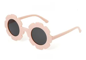 Detailed side view of pink flower-shaped matte sunglasses for kids with grey lenses