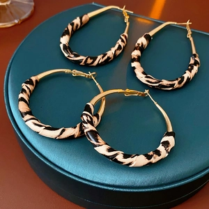 Détail de créoles dorées avec tissu imprimé zèbre, ensemble de deux paires chic