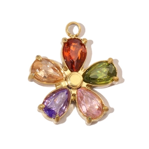 Close-up of golden flower pendant with colorful drop-shaped stones on white background