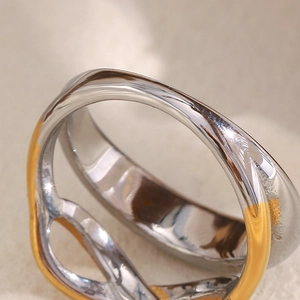 Dettaglio macro degli anelli intrecciati in acciaio inossidabile bicolore placcati oro 18K