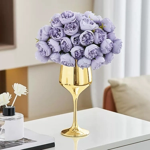 Elegante ramo de peonías púrpuras en un jarrón de cáliz dorado para decoración de hogar de lujo