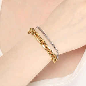 Detail eines mehrlagigen Armbands aus goldener Panzernote und silberner Kette