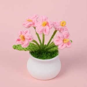 Handmade crochet pink forget-me-not flowers in a white ceramic pot for home office decor