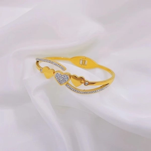 Elegant gold heart bracelet with sparkling zircon accents on white satin background