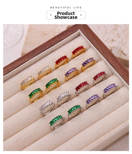 Detail of gold and silver hoop earrings with multicolored rectangular zircon stones