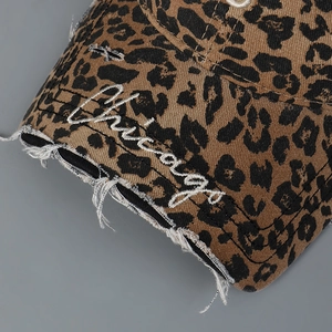 Close-up of distressed leopard baseball cap with white Chicago embroidery on curved brim
