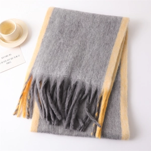 Close-up of gray and yellow patchwork scarf with fringe and soft cashmere-like texture