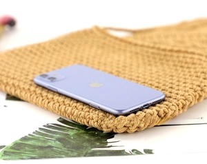 Detailansicht der handgewebten Strohtasche mit Textur und Handy als Größenreferenz