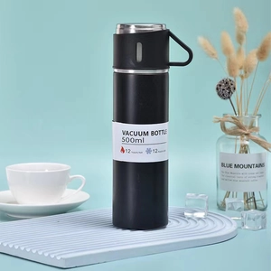 Black 500ml vacuum insulated stainless steel water bottle with lid handle on blue background