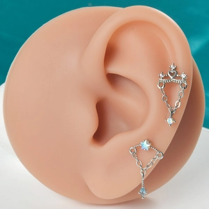 Vue détaillée de clous d'oreilles papillon en argent avec pierres bleues sur modèle