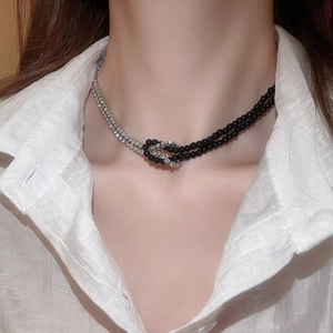 Dettaglio della collana a nodo bicolore nera e argento con strass sul collo