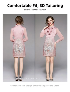 Detail of pink embroidered dress featuring floral patterns and ruffle collar design