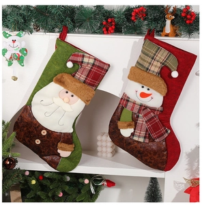 Detail of Santa and Snowman 3D plush Christmas stockings hanging on a white fireplace