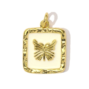 Macro shot of gold butterfly charm with cream enamel inlay and hammered texture finish