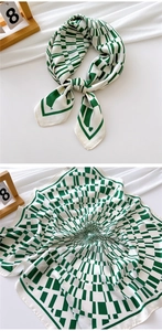 Detail of green and white geometric silk scarf with premium gloss and fine stitching