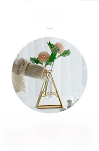 Detail of geometric gold metal vase with glass tube and decorative Love lettering