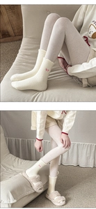 Close-up of fluffy white winter socks with pink bow detail and cozy fleece texture