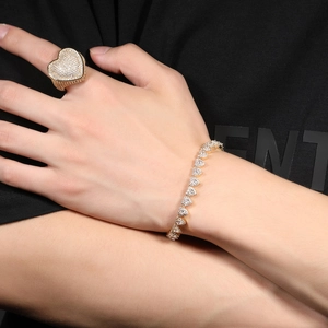 Close-up of golden heart ring and matching bracelet set with sparkling cubic zirconia stones