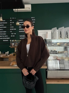 Detailansicht einer dunkelbraunen Strickjacke mit hohem Kragen und Reißverschluss