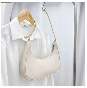 Detailed close-up of a beige nylon hobo bag hanging on a minimalist hanger