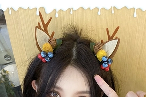 Detail of Christmas reindeer antler hair clip with pine cones and berries on model