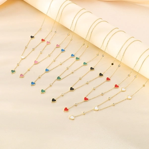 Detail showing various colors of heart pendant necklaces with crystals and gold chains