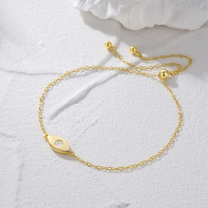 Close-up of golden evil eye bracelet with clear zircon and adjustable drawstring clasp