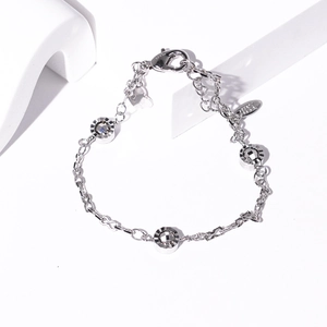 Detail of silver chain bracelet with three faceted metal spheres and a lobster clasp