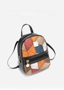 Detail of mini backpack showing diamond patchwork leather and gold zipper hardware