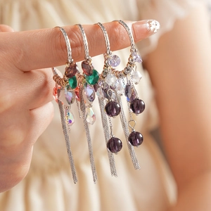 Vue détaillée des boucles d'oreilles ethniques avec cristaux et pompons colorés