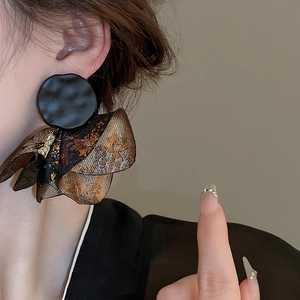 Detailed close-up of vintage petal-shaped drop earrings with textured metallic finish